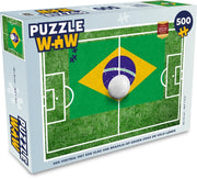 Puzzel Vlag Brazilië 500 stukjes - Een voetbal met een vlag van Brazilië op groen gras en veld lijnen
