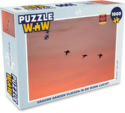 Puzzel 1000 stukjes volwassenen Grauwe Gans 1000 stukjes - Grauwe ganzen vliegen in de rode lucht  - PuzzleWow heeft +100000 puzzels