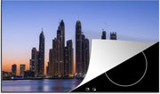 Luxe inductie beschermer Dubai Marina - 90x52 cm - zonsopkomst verborgen achter skyline van Dubai Marina  - inductiebeschermer
