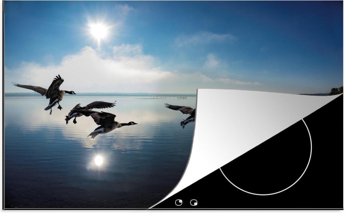 Luxe inductie beschermer Ganzen - 78x52 cm - silhouet van ganzen die op zonnige dag over water vliegen  - inductiebeschermer