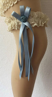 Kousenband ivoor met licht blauw satijnen linten en een blauw roosje voor de bruid